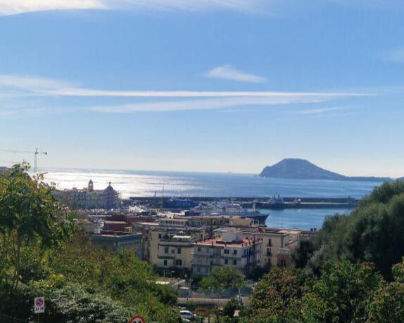 Veduta panoramica dall'alto del mare e del porto di Pozzuoli con il cielo azzurro e la splendita costa